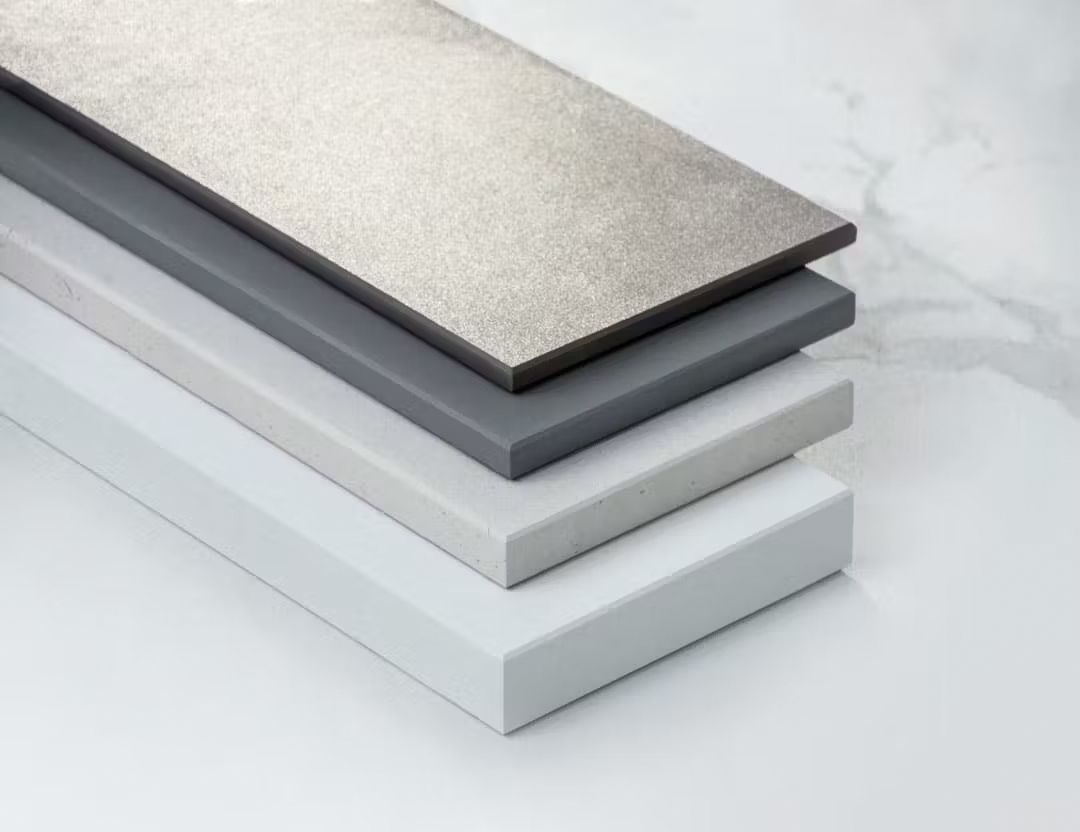 Una pila de azulejos de diferentes colores están colocados uno encima del otro sobre una mesa.