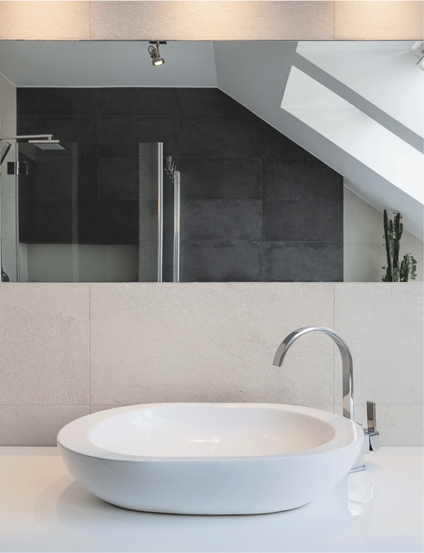 Un baño con lavabo y un gran espejo.