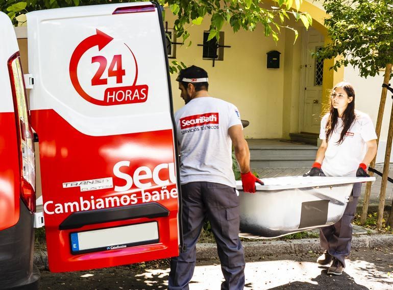 Un hombre lleva una bañera delante de una furgoneta que pone 24 horas