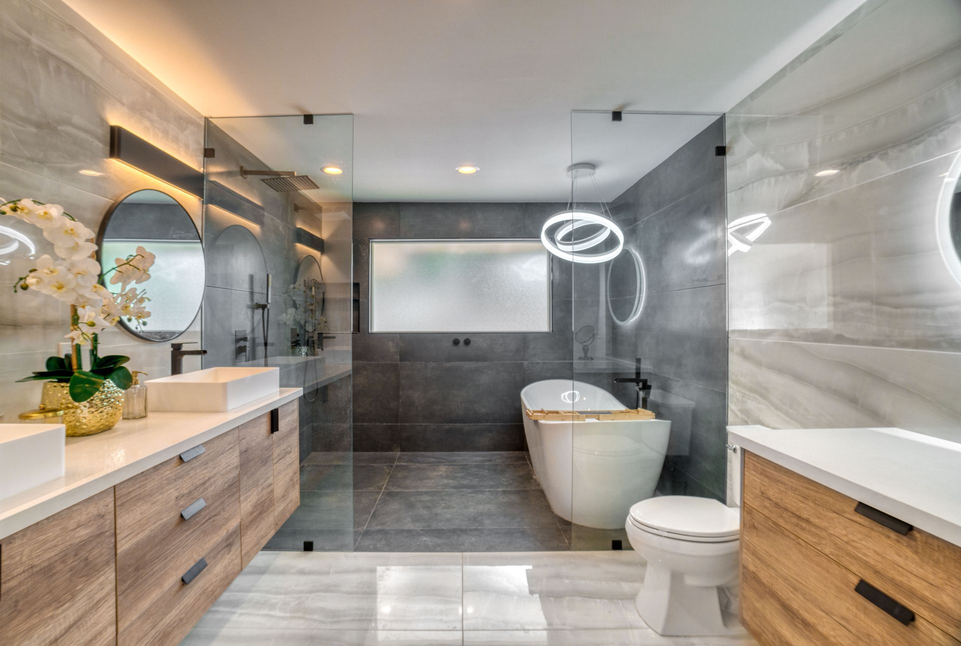 Un baño con lavabo, inodoro, espejo y plato de ducha.