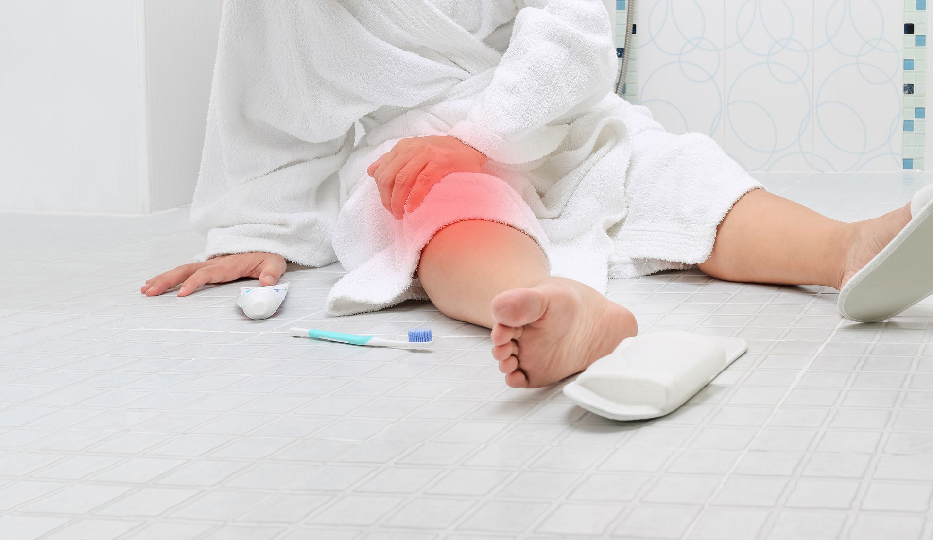 Una mujer está sentada en el suelo con dolor de rodilla.