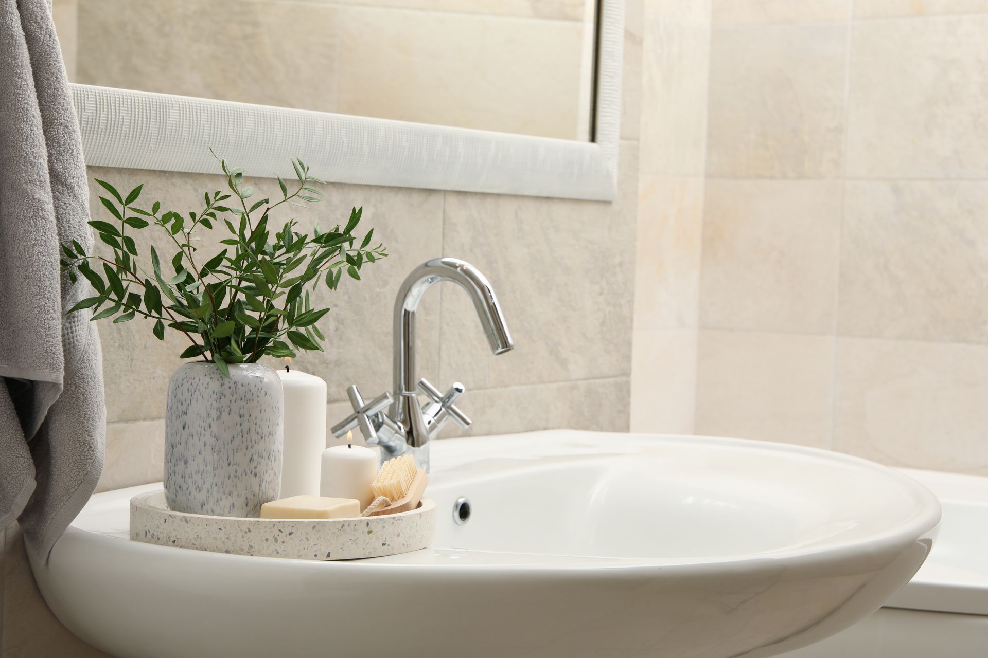 Un lavabo de baño con una planta y velas encima.