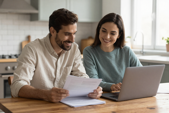 Homeowner couple reviewing financing paperwork at a kitchen table