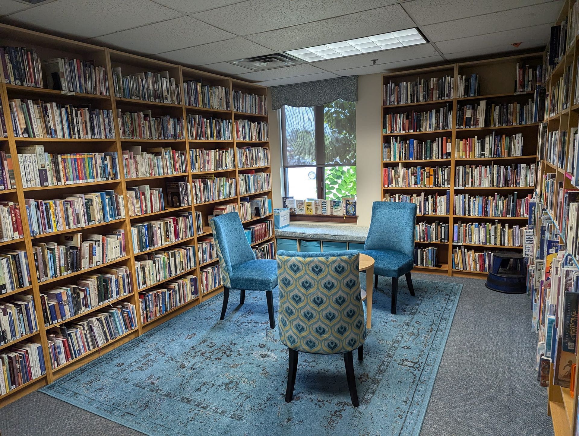 A library filled with lots of books and chairs.