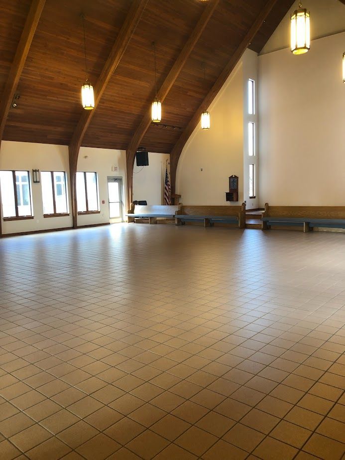 A large empty room with a tiled floor and a wooden ceiling