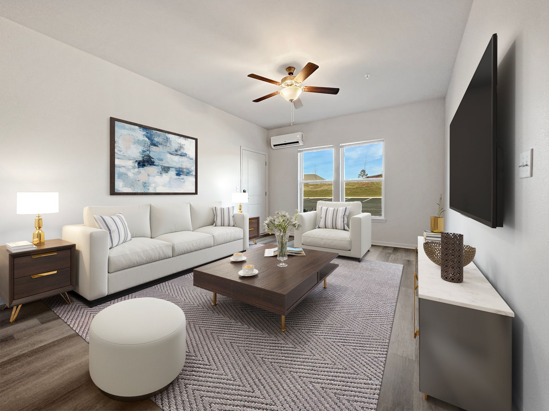 Bright modern living room with white sofa, armchair, coffee table, large wall TV, and mountain-view window