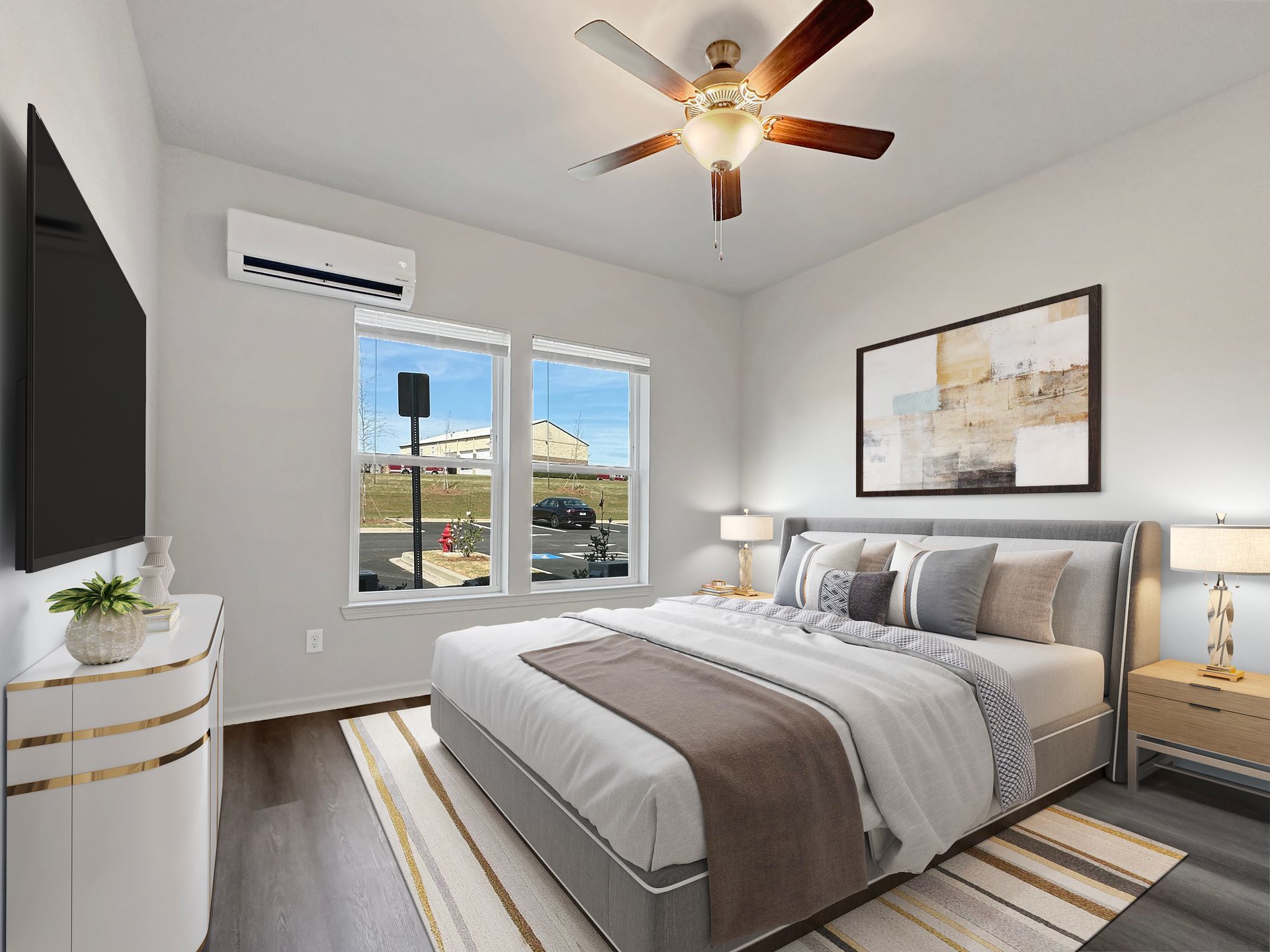 Bright modern bedroom with bed, ceiling fan, wall-mounted TV, and large windows with city view