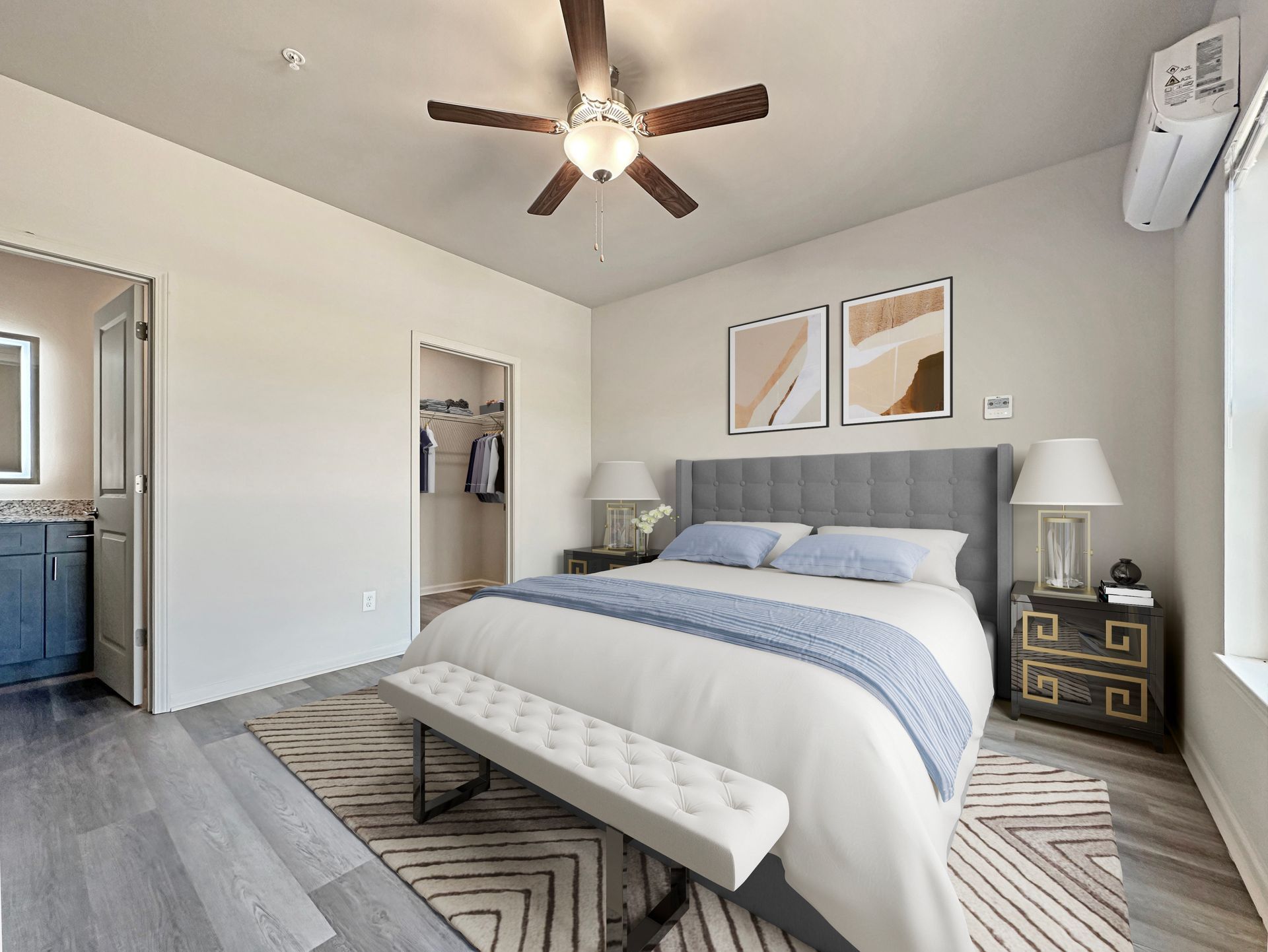 Bright bedroom with gray bed, patterned bench, ceiling fan, nightstand, and open closet door
