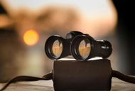 A pair of binoculars sitting on top of a wooden box.
