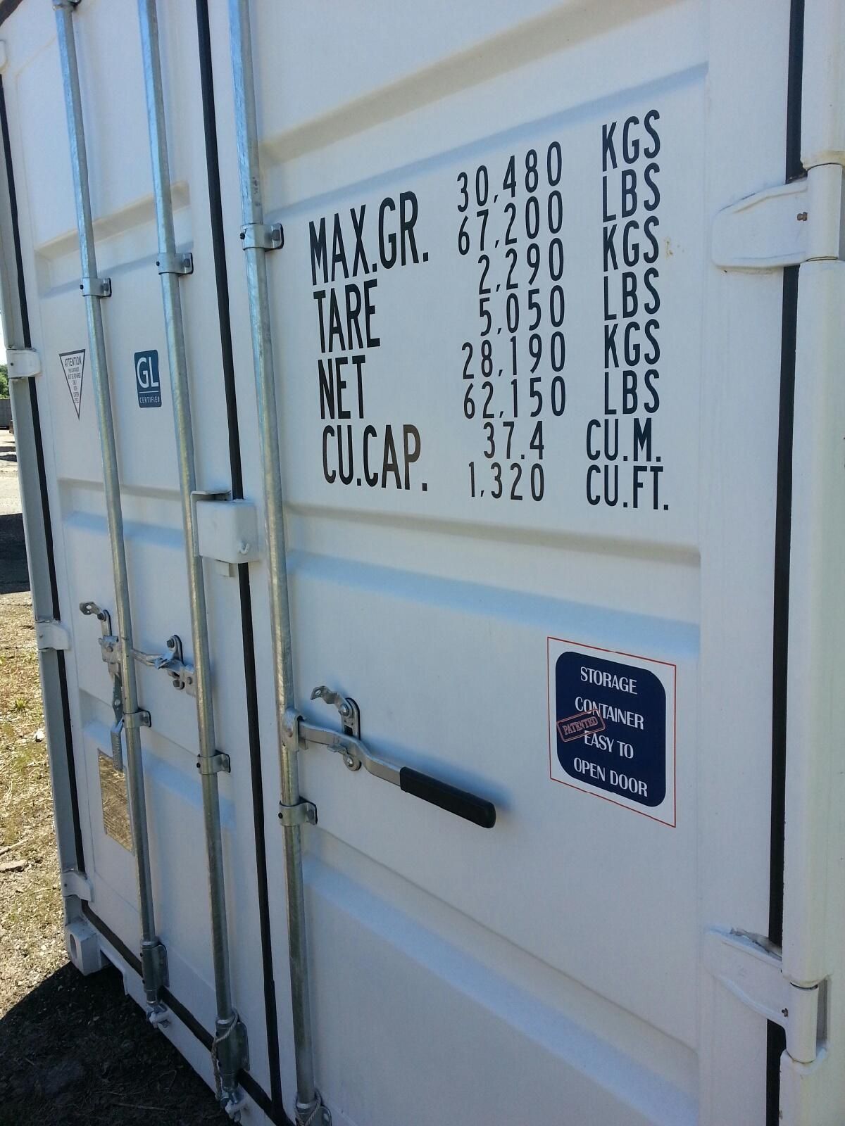 White shipping container door with weight markings and a blue safety sign, viewed close up