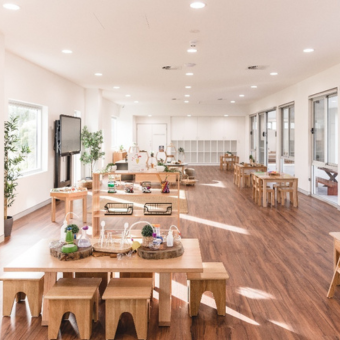A large room with wooden tables and stools A large room with wooden tables and stools