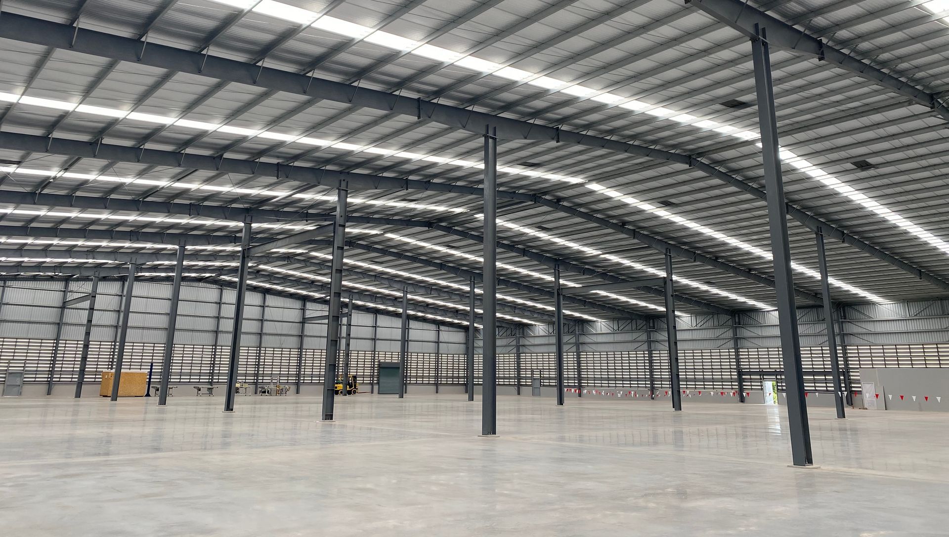 A large empty warehouse with lots of lights on the ceiling