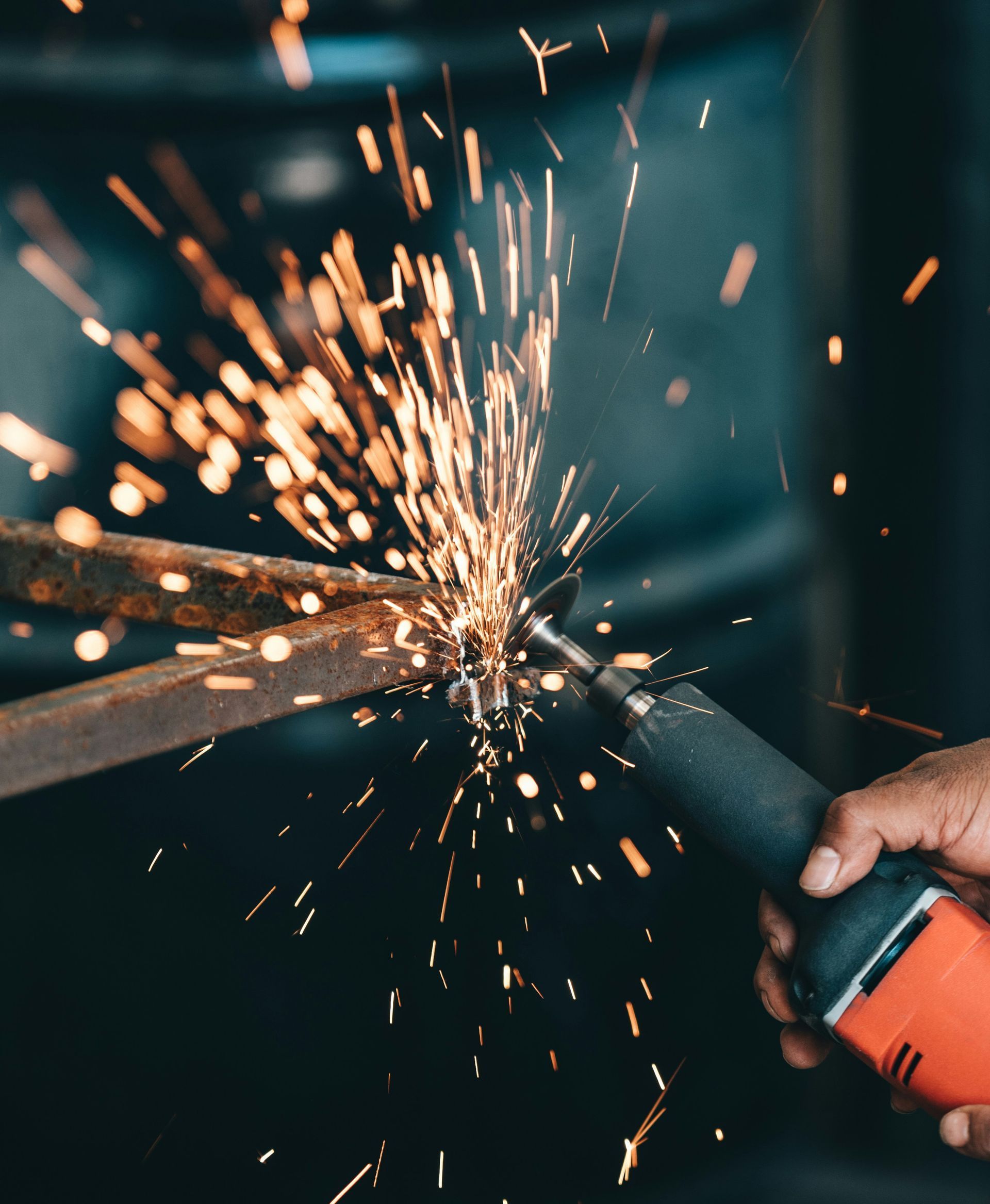 A close up of a pair of scissors cutting a piece of metal with sparks coming out of it.