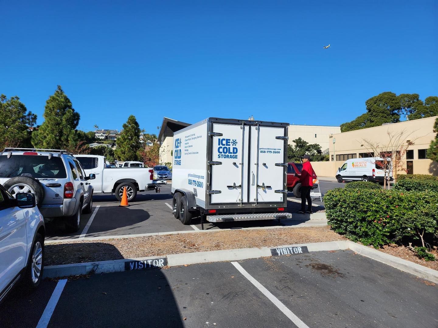A white trailer with the word ice on it is parked in a parking lot