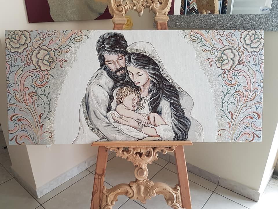 Un dipinto della sacra famiglia è su un cavalletto di legno.