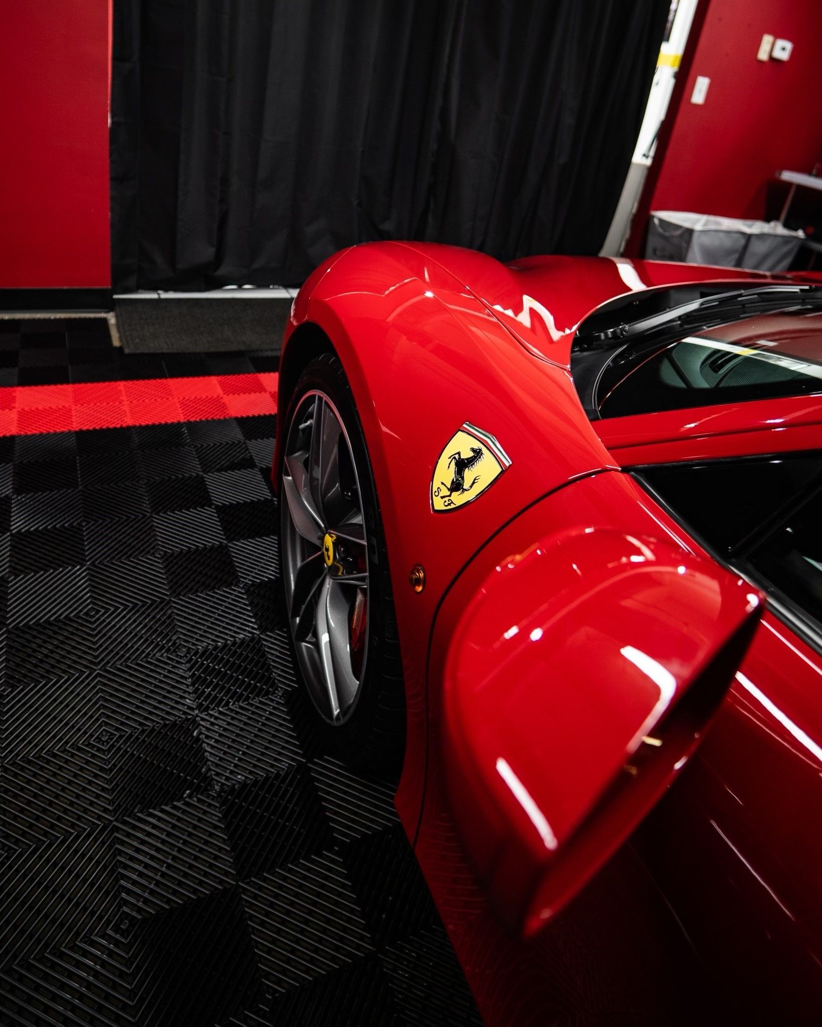 A red ferrari sports car is parked in a garage