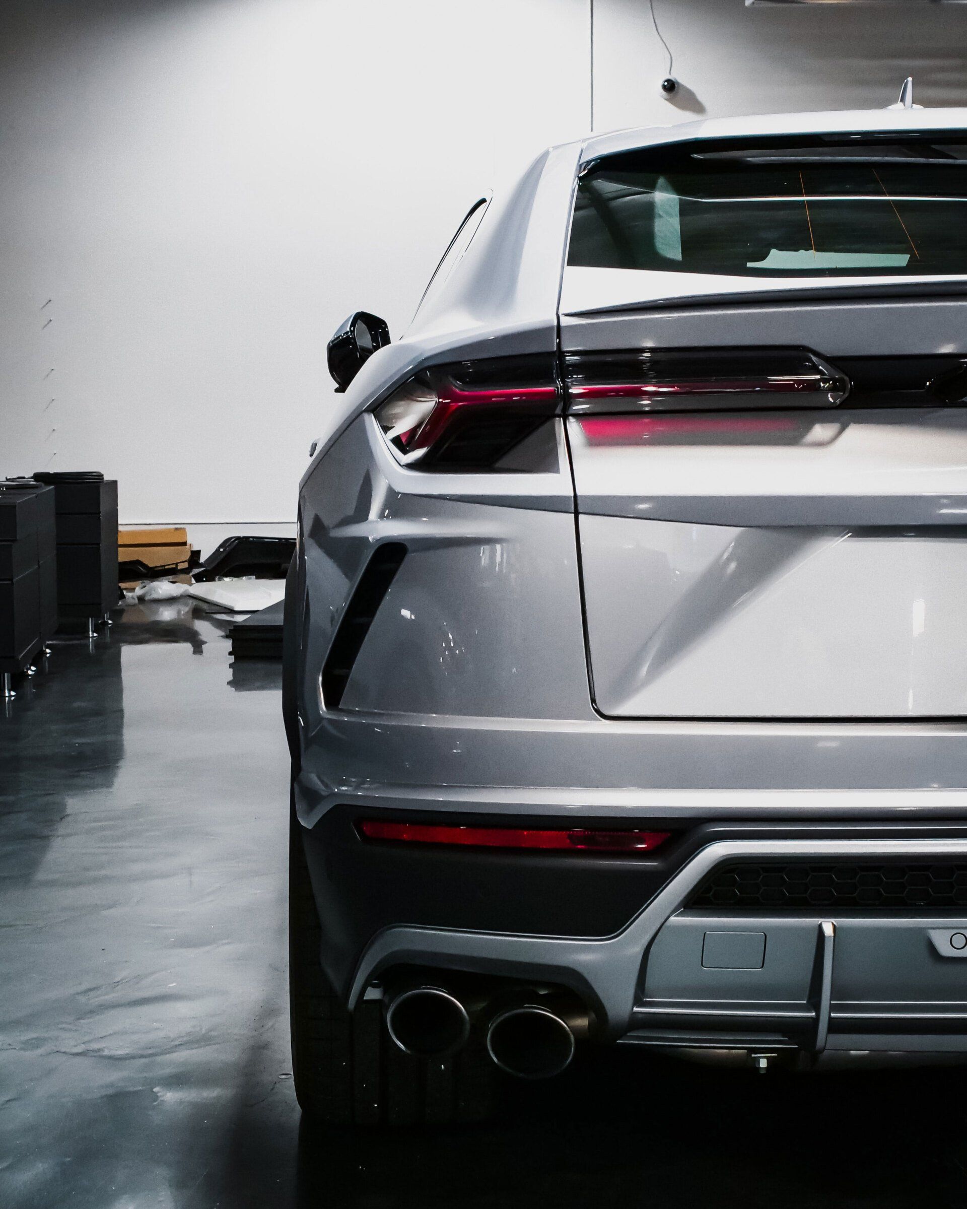 A silver car is parked in a garage with the trunk open