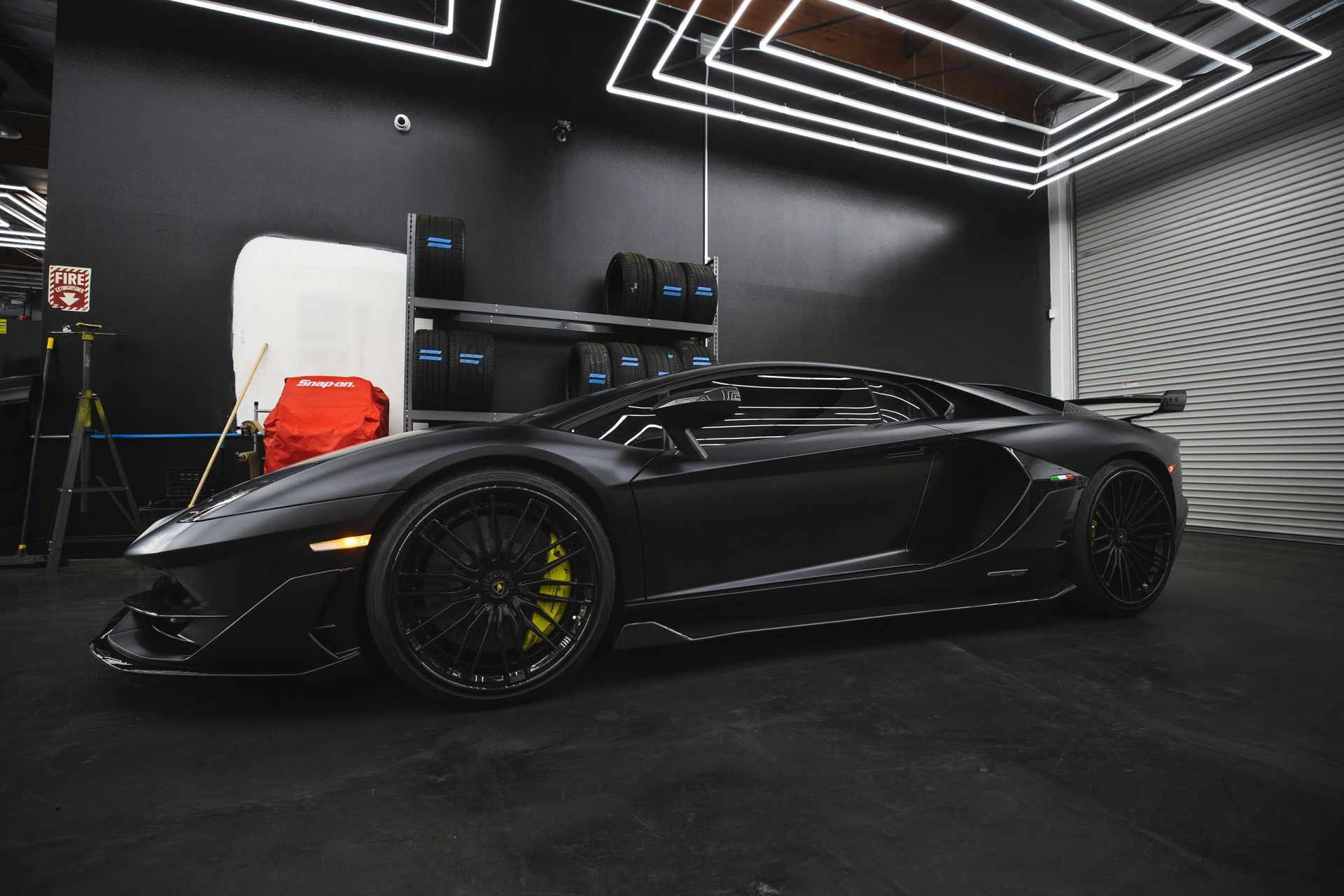 A man is polishing a car in a garage