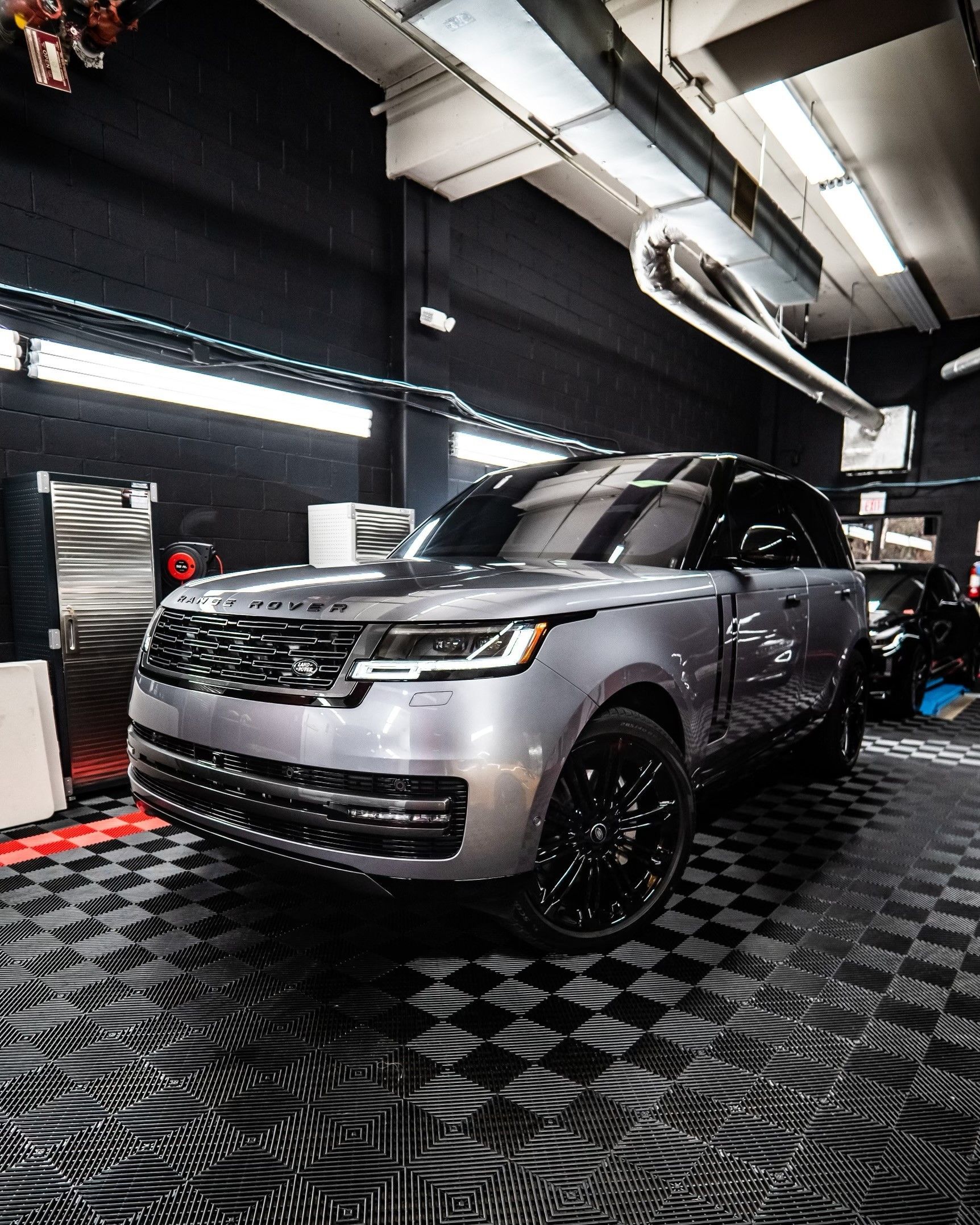 A silver range rover is parked in a garage.