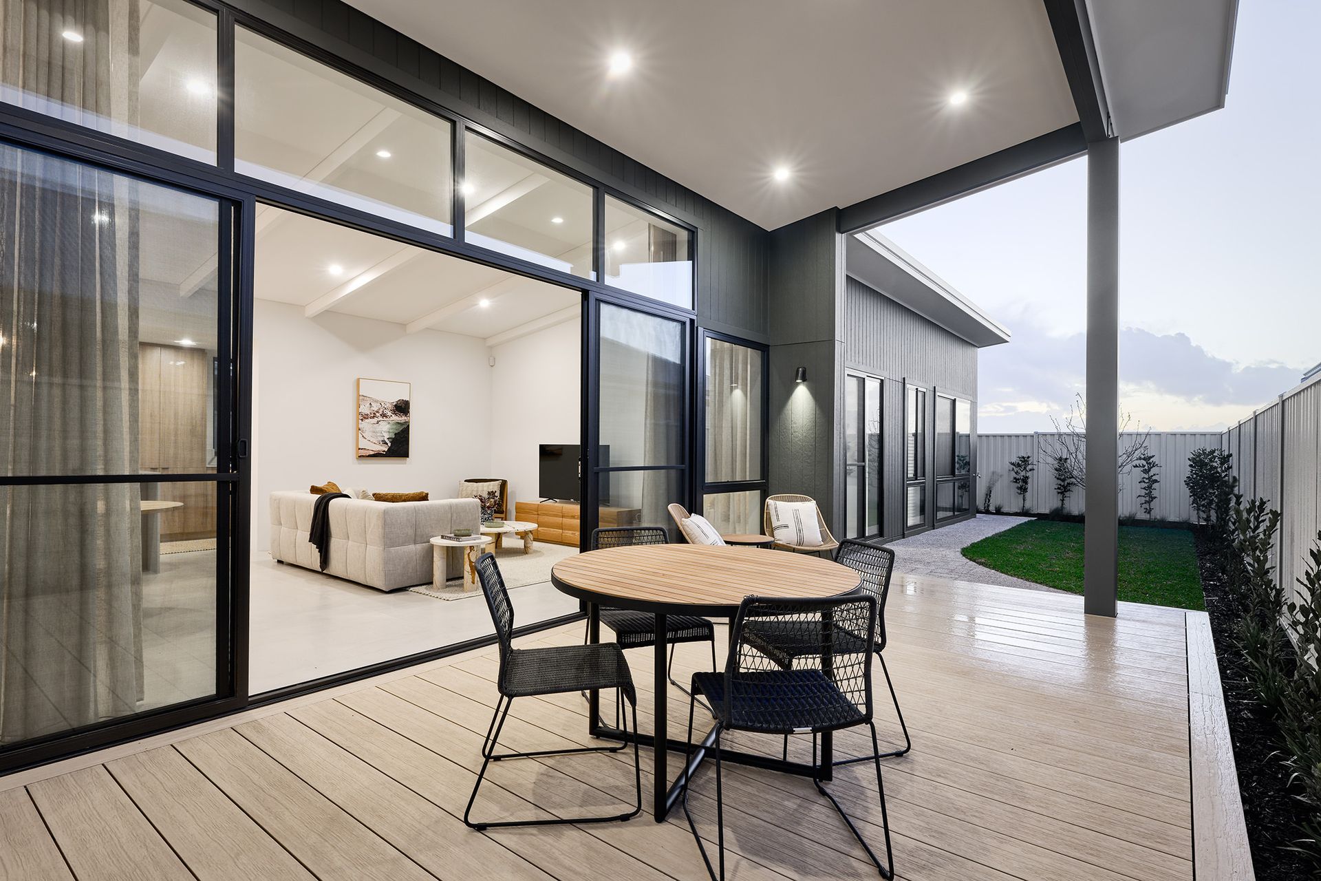 A Patio with a round table and chairs and a living room in the background  — Superior Windows & Doors Taree, NSW