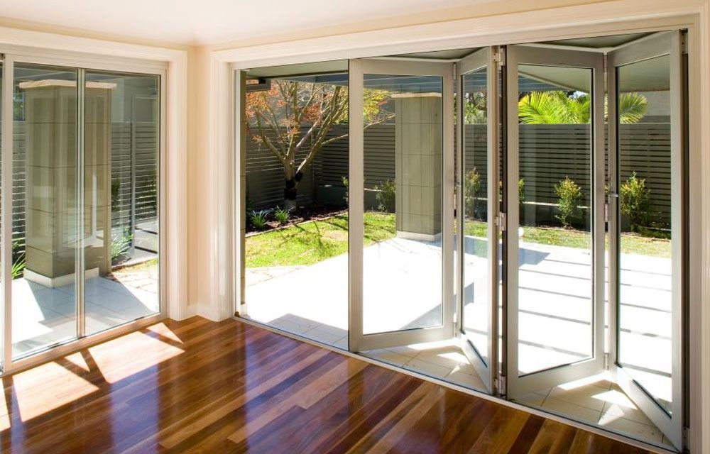 An Empty Room With Hardwood Floors and Sliding Glass Doors — Superior Windows & Doors Taree, NSW