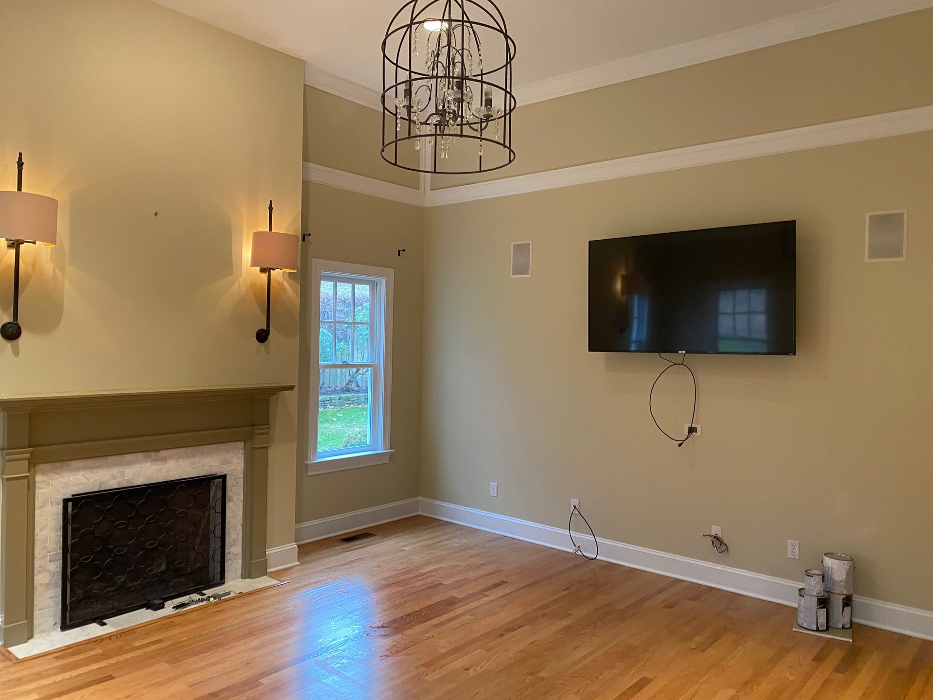 An empty living room with a fireplace and a flat screen tv on the wall.