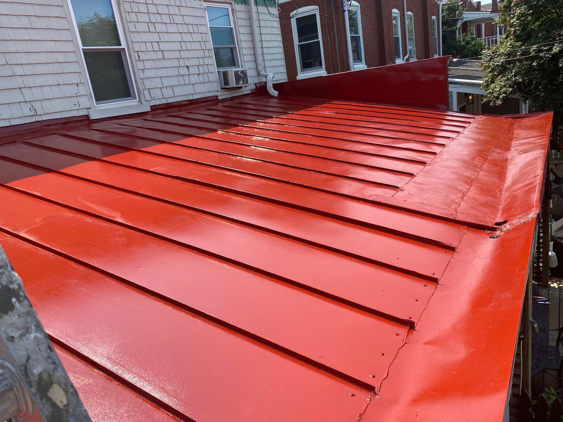 A red roof is sitting on top of a brick building.