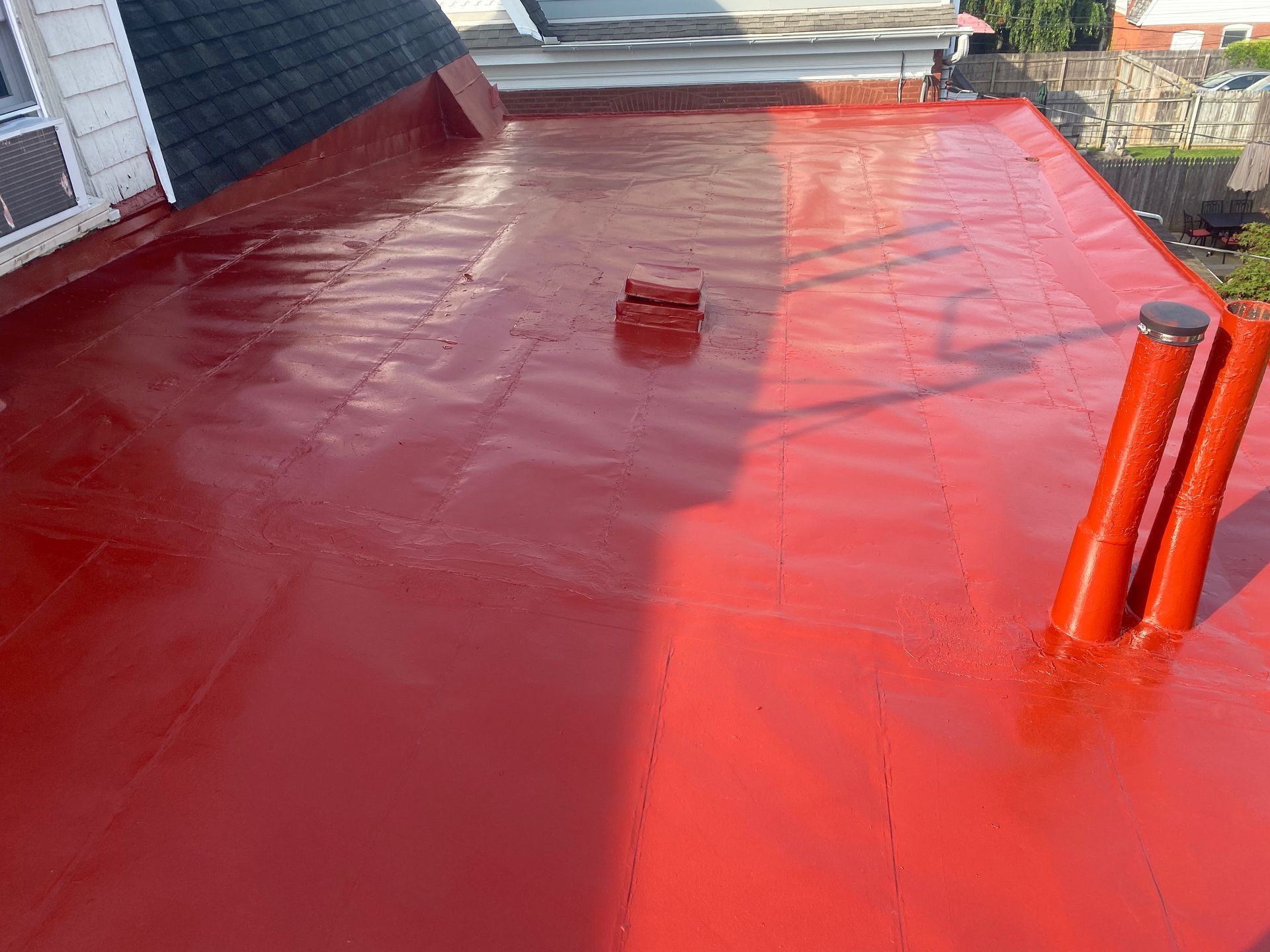 A red roof with two red pipes on it.