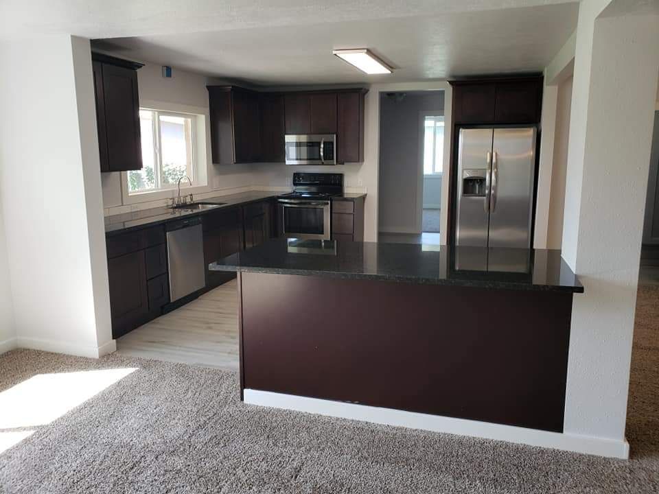 A kitchen with stainless steel appliances and brown cabinets
