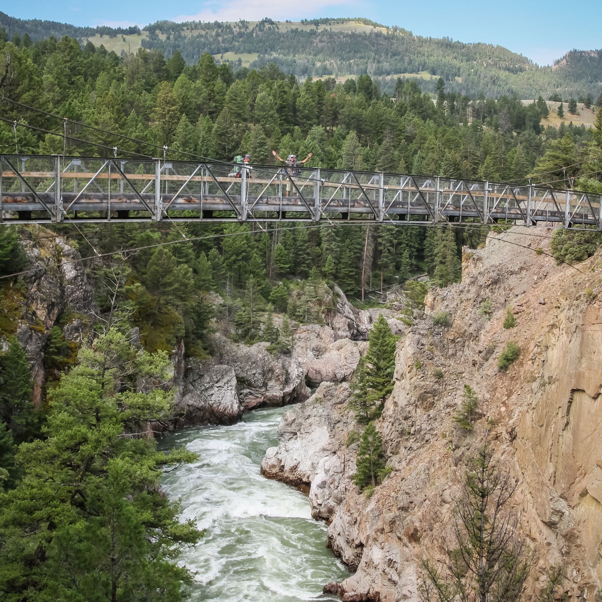 Suspension Bridge, Yellowstone River Backpackers stop for a photo on a suspension bridge located high above the Yellowstone River.