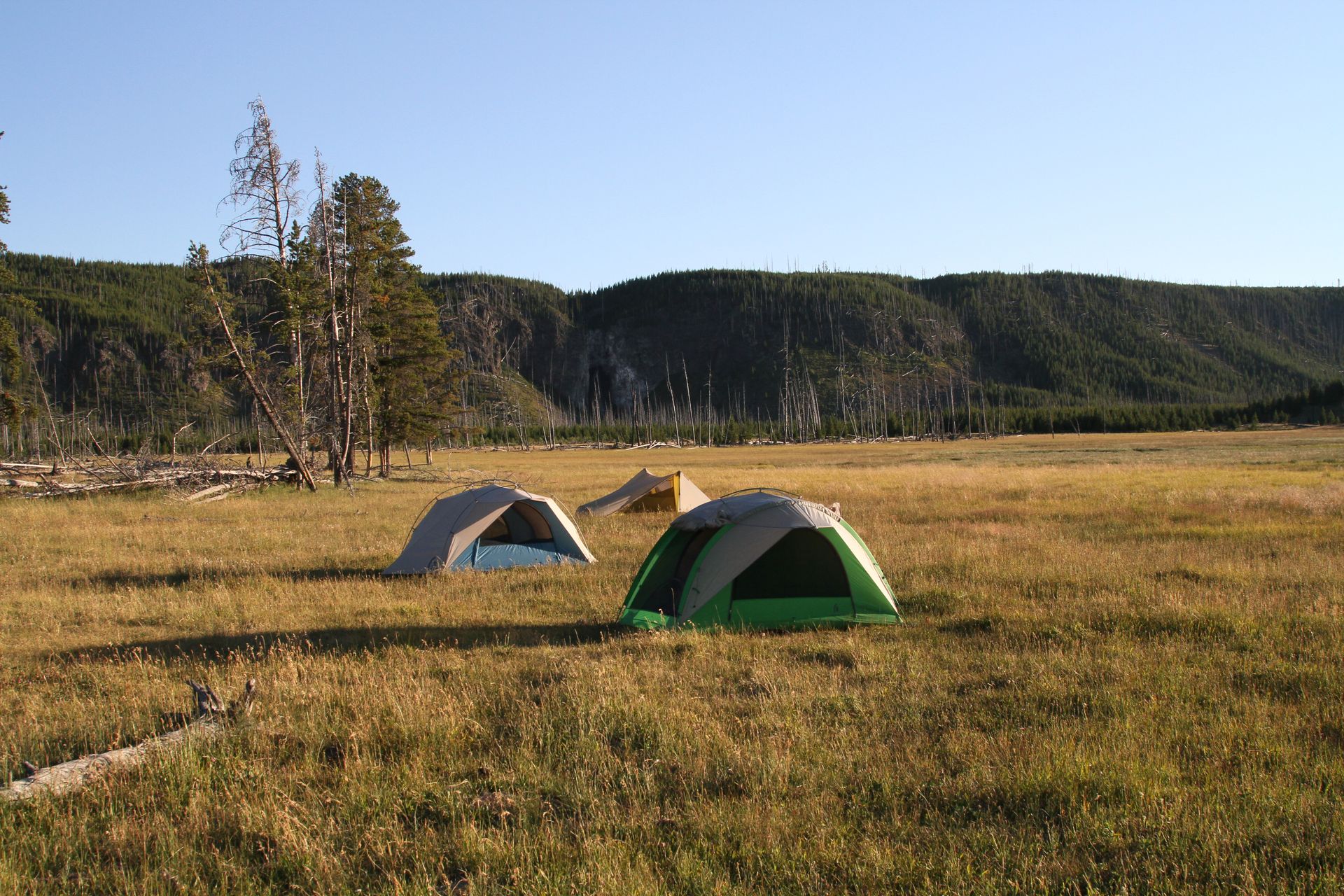 Backpackers enjoy clear blue skies as the sun sets over their backcountry campsite near Fairy Falls.
