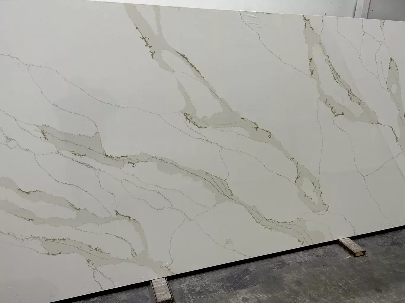 A large white marble slab is sitting on top of a concrete floor.