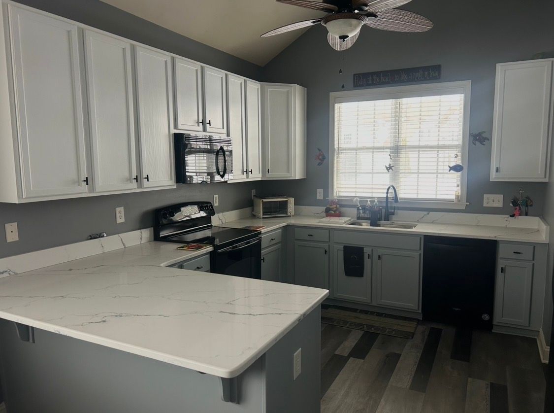 A kitchen with a large island , sink , stove and hood.