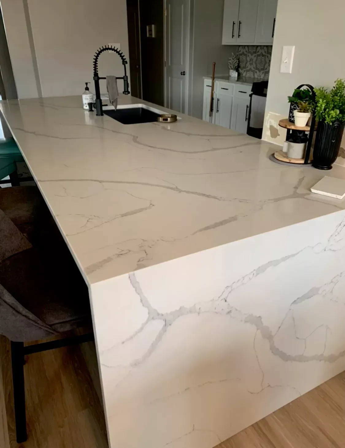 A kitchen with a large white counter top and a sink.