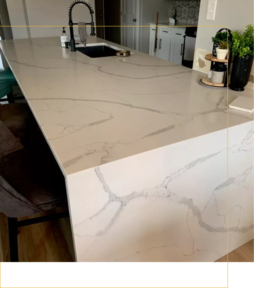 A kitchen with a large white counter top and a sink.