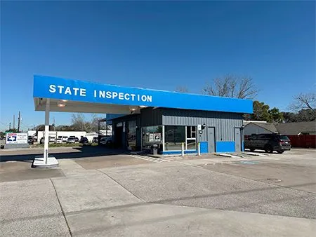 Blue state inspection station building with parking lot under clear sky | Cruz-N-Carz