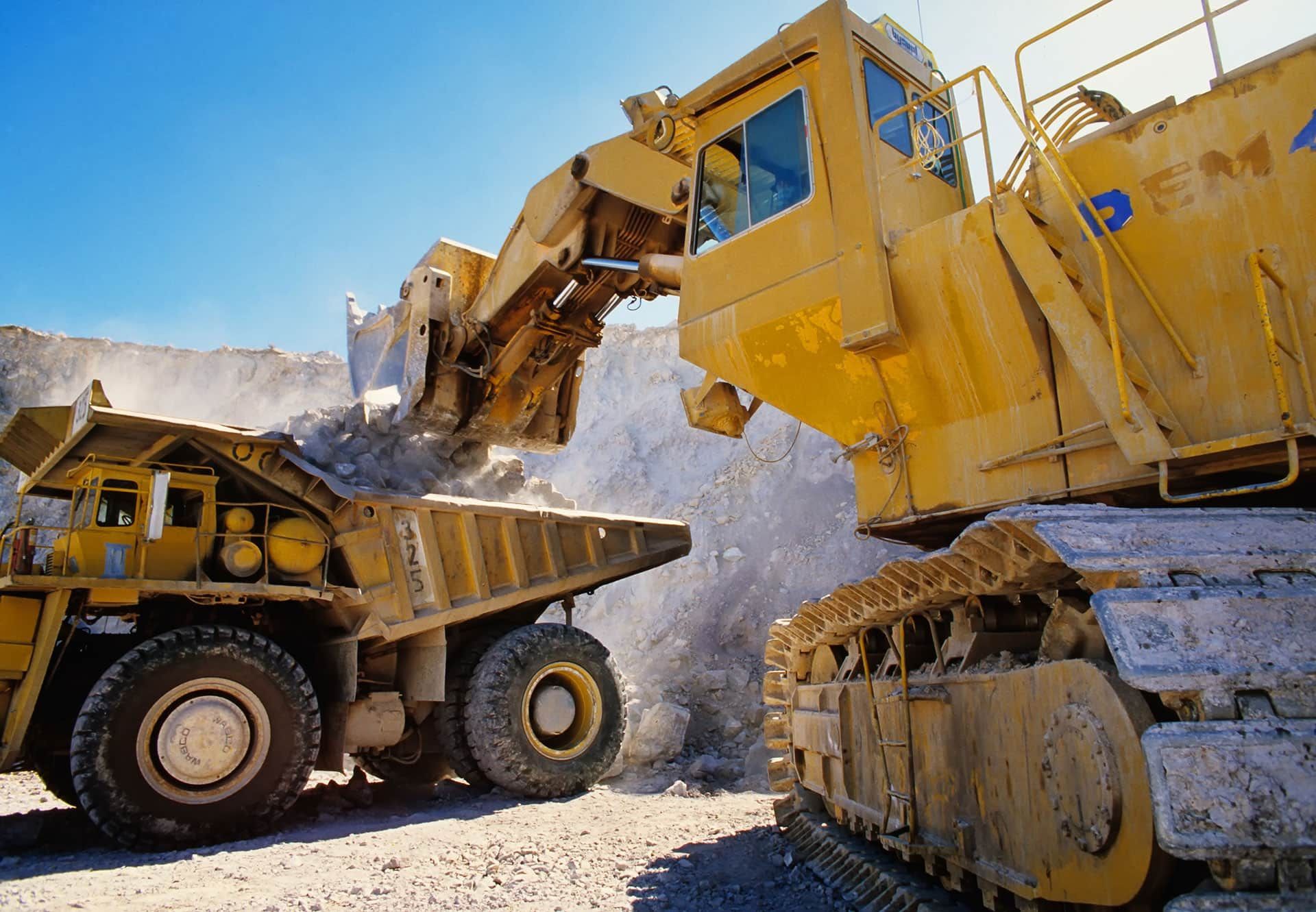 Excavator and dump truck operating on-site, illustrating the importance of high-quality heavy machin