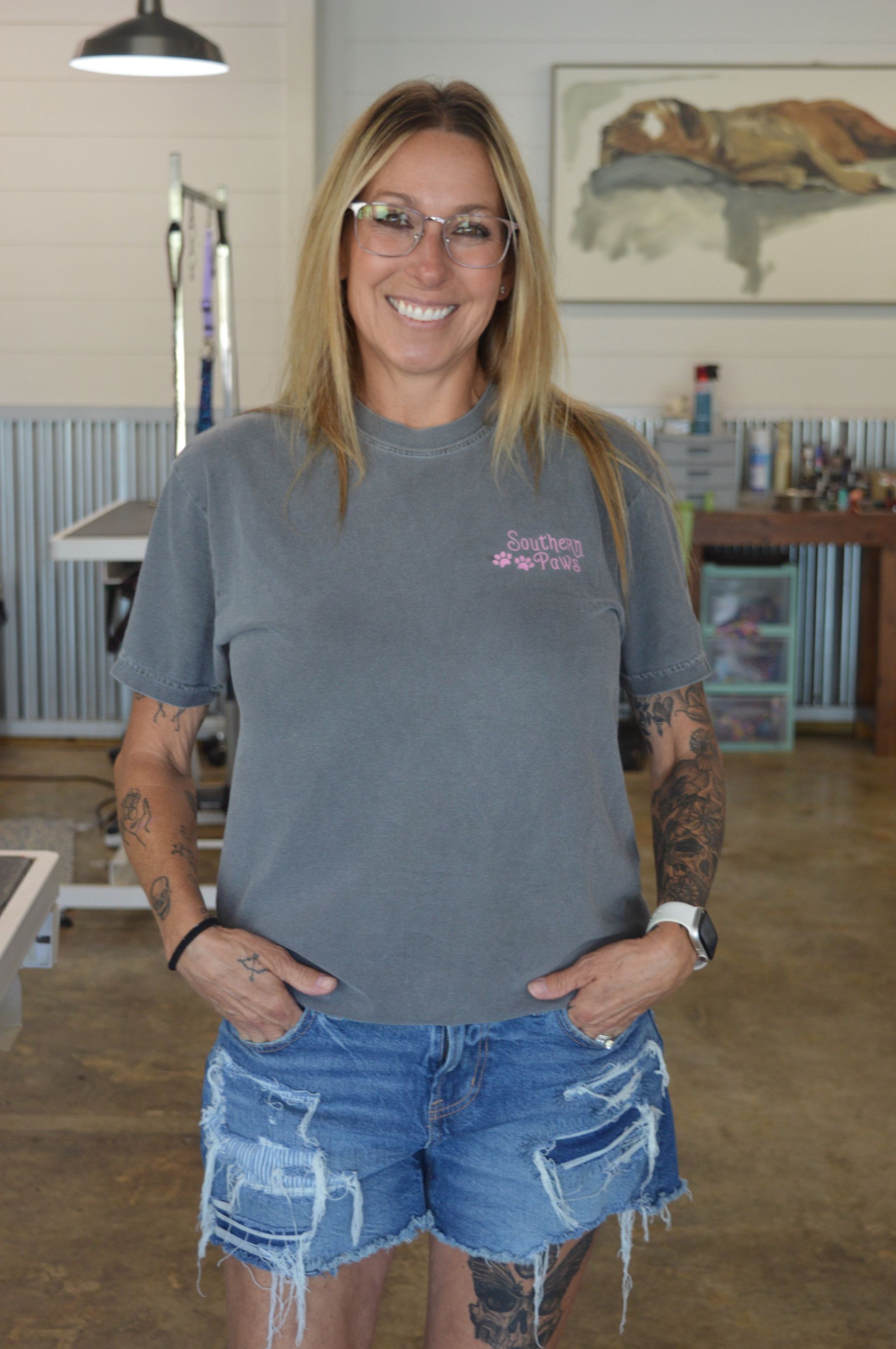 A woman is standing in a room with her hands in her pockets.