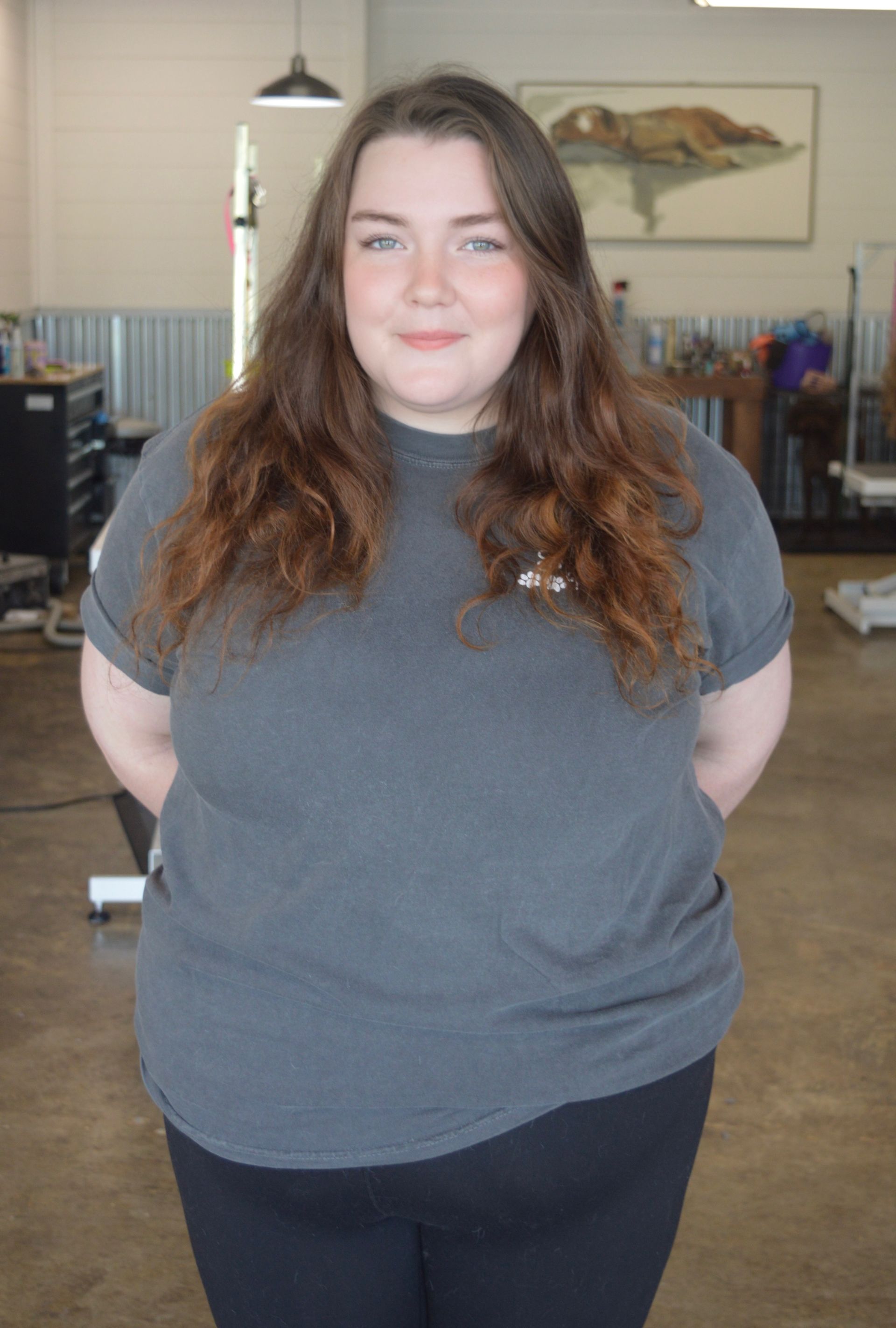 A young woman with long hair is wearing a green t-shirt and leggings.