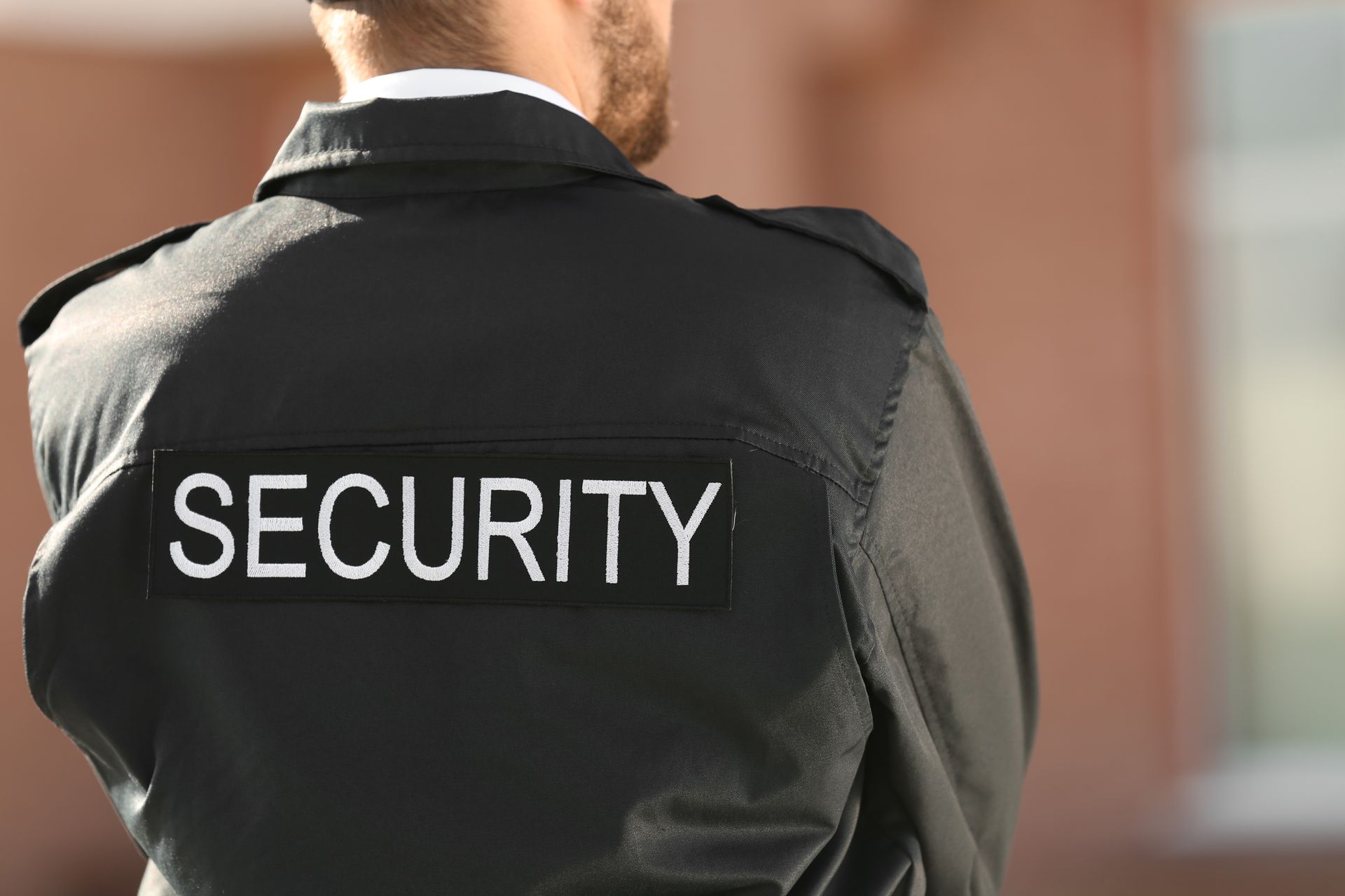 Industrial security services officer monitoring a warehouse facility entrance. Industrial security services officer monitoring a warehouse facility entrance.