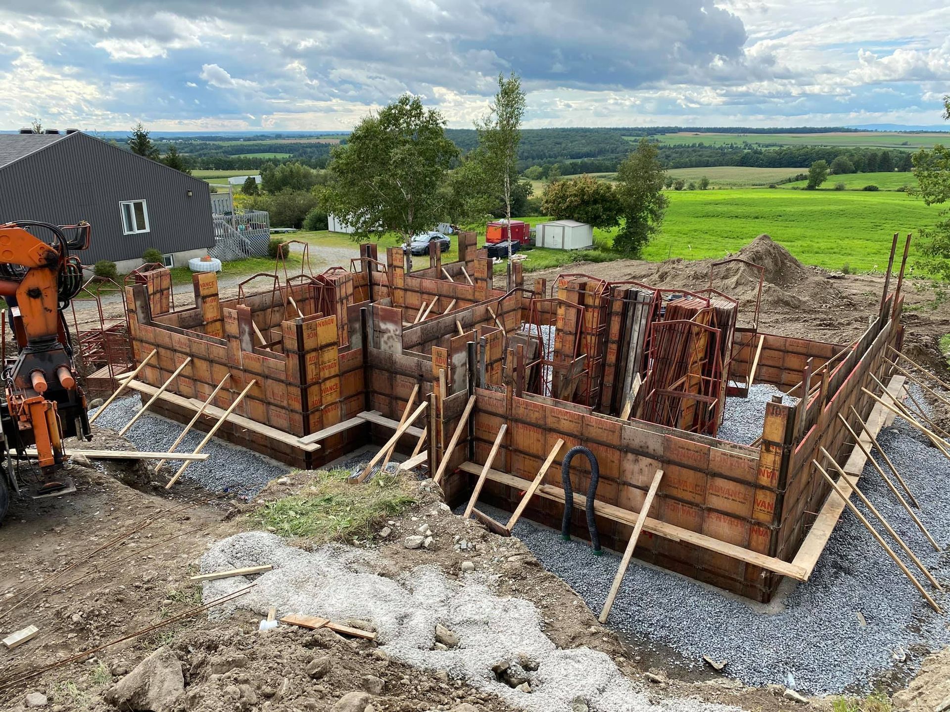 Une maison est en construction au sommet d'une colline de terre.