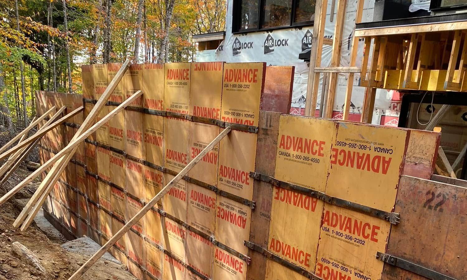 Un mur de béton est en train d'être construit dans les bois.