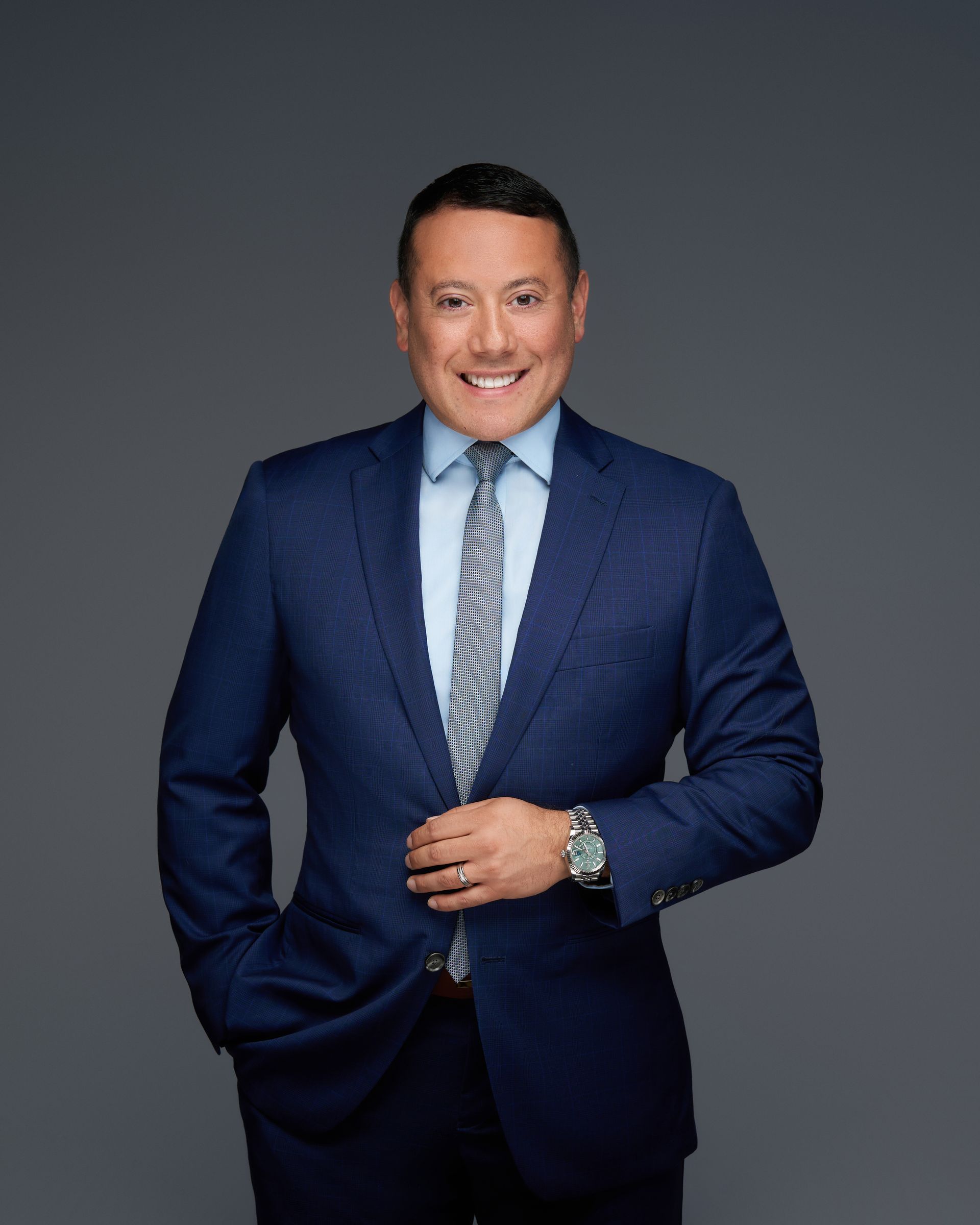Richard Gonzales in a suit and tie is smiling for the camera.