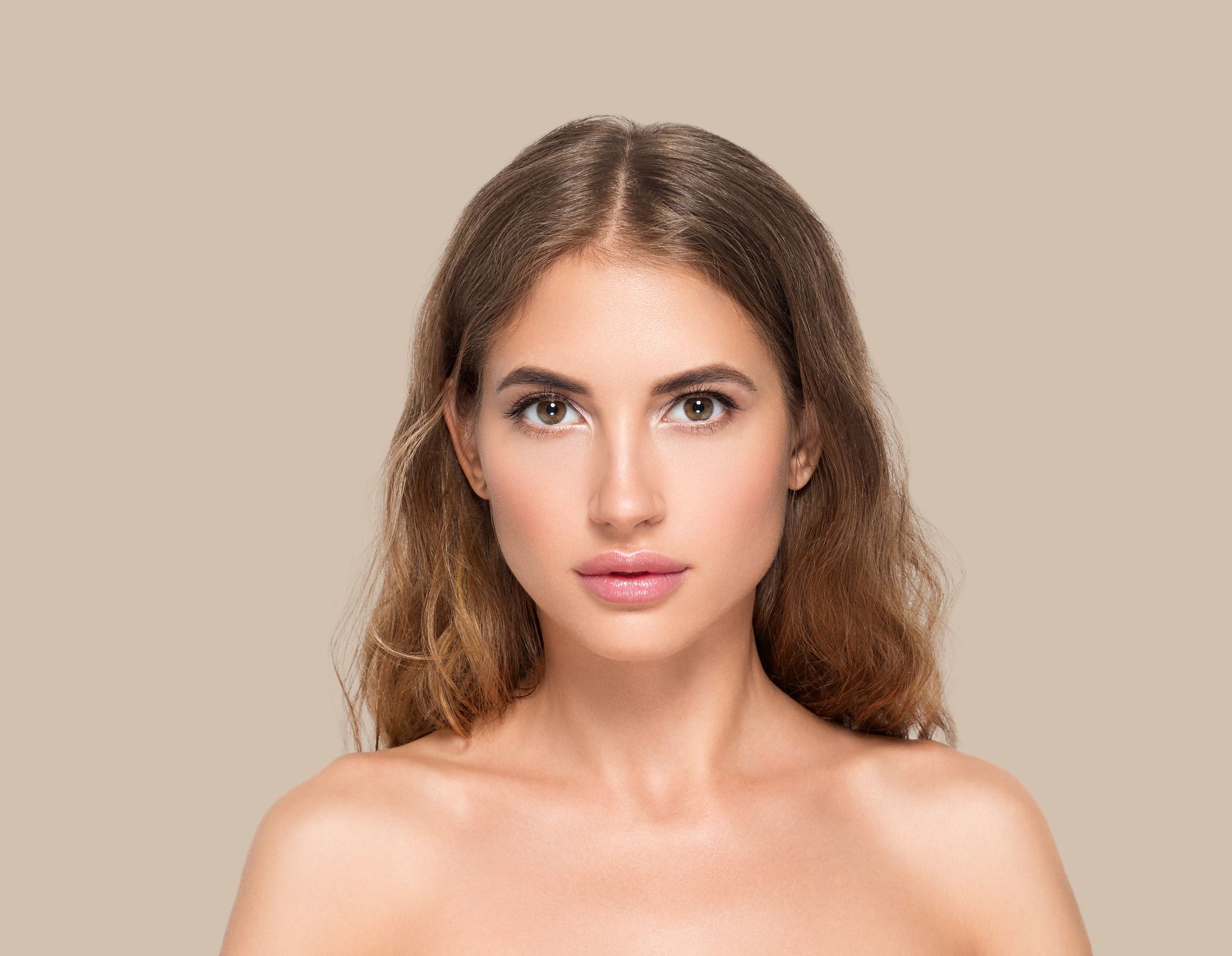 A woman with long hair and no shirt is looking at the camera.