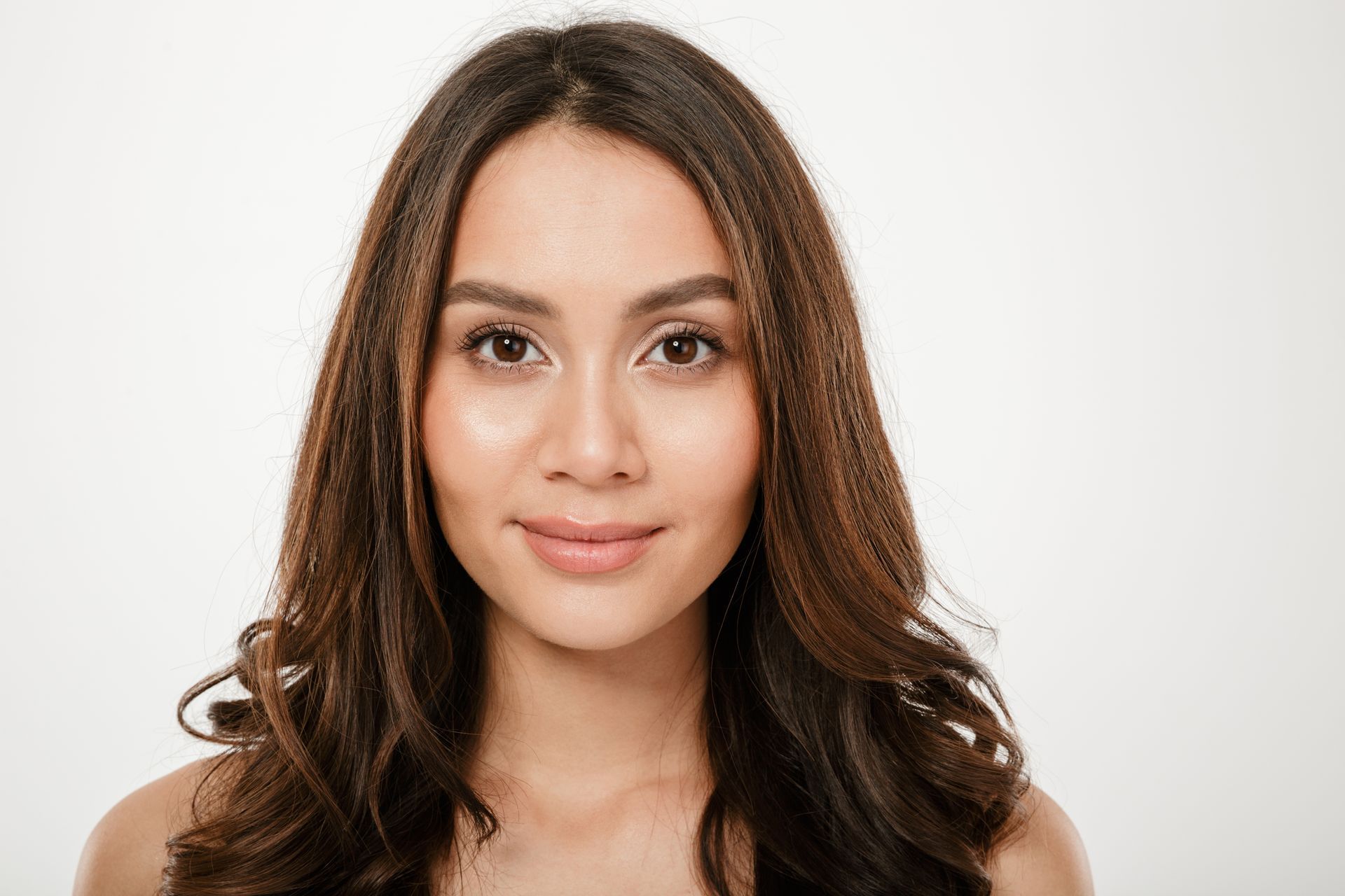Portrait of a smiling woman with long hair looking at the camera over white background