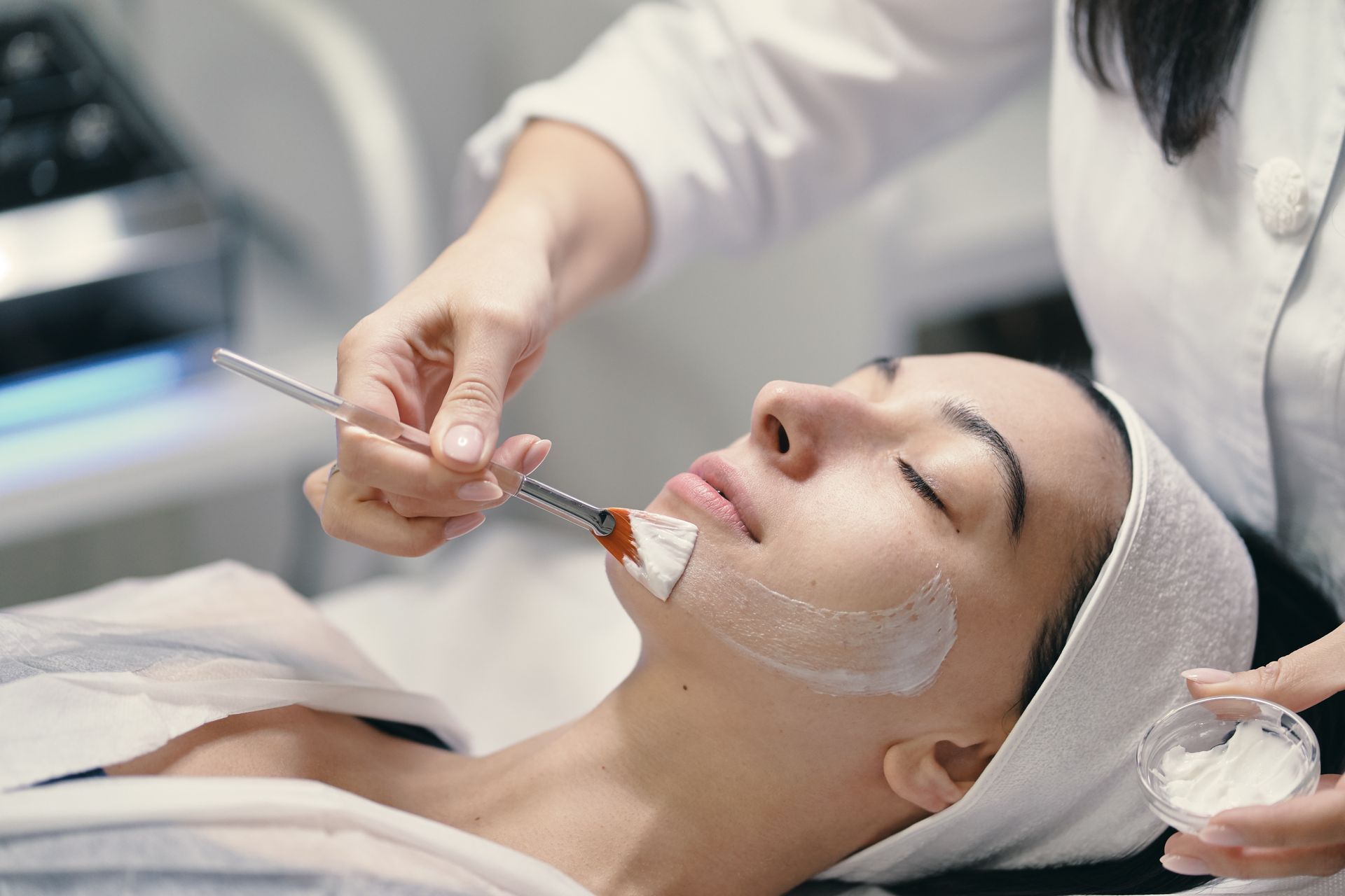 a woman is getting a facial treatment with a brush