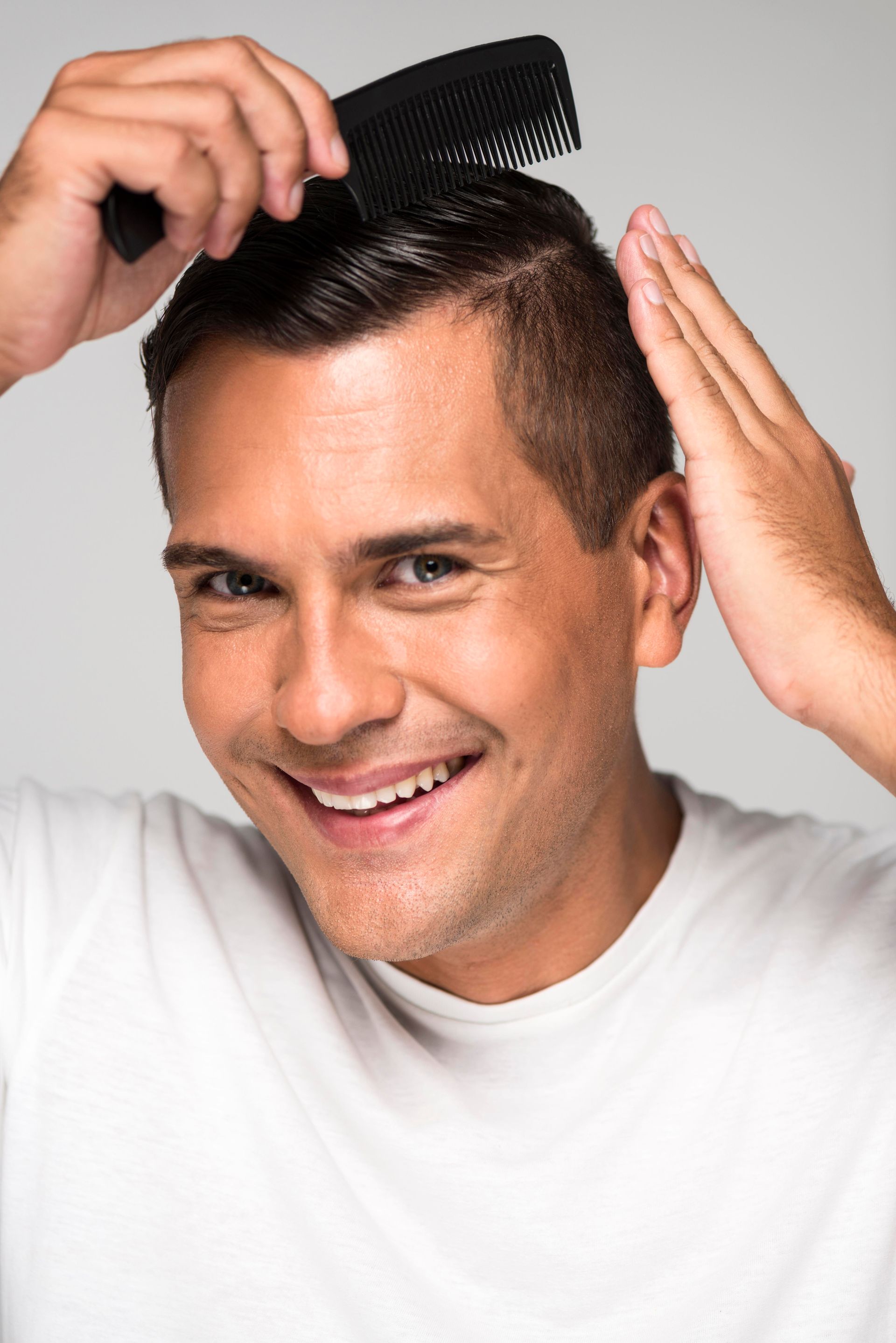 a man in a blue shirt is brushing his hair