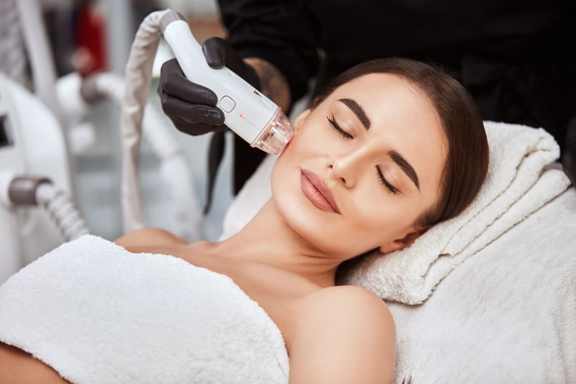woman receiving facial treatment with a laser