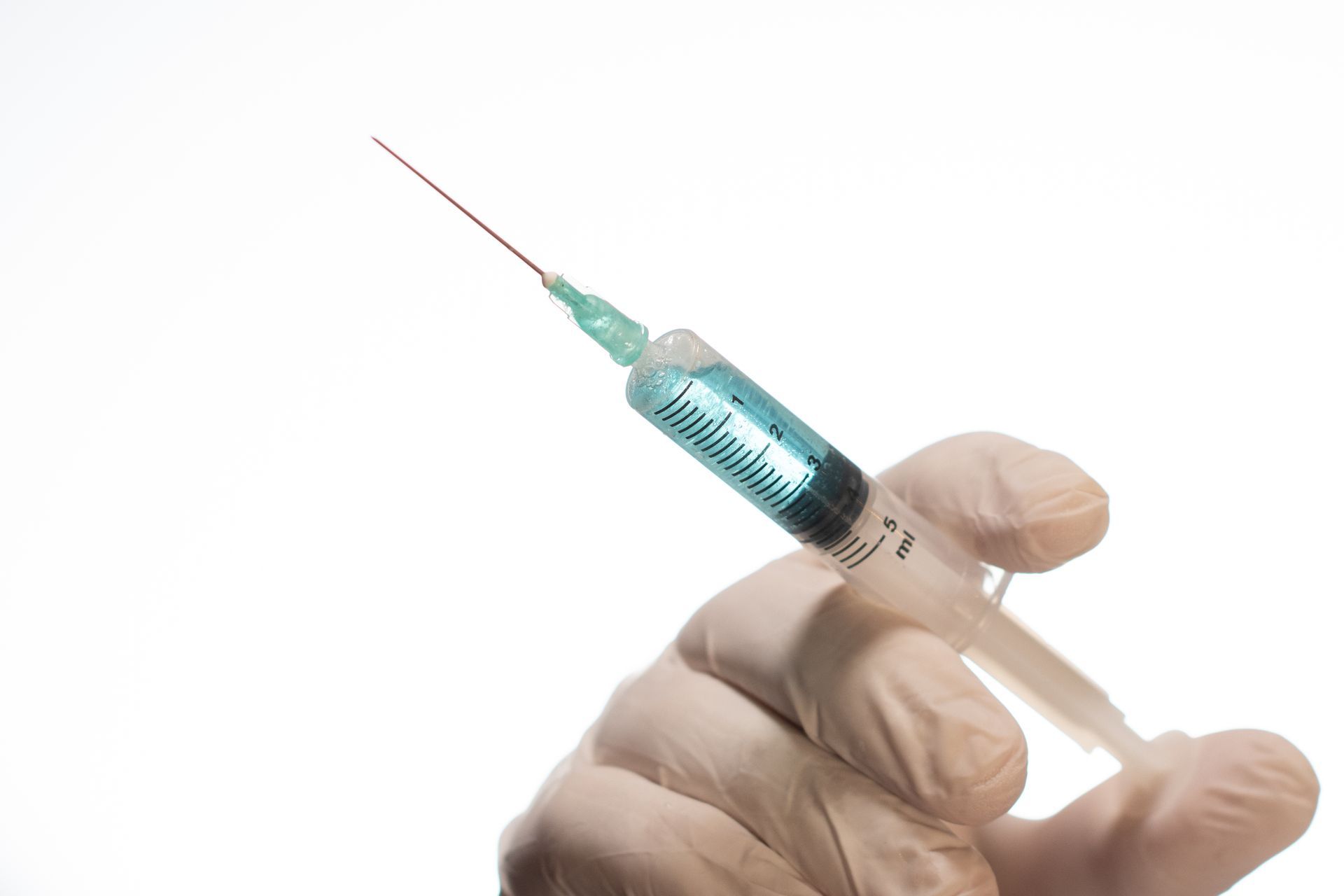 a person is holding a syringe that says 5 ml on it