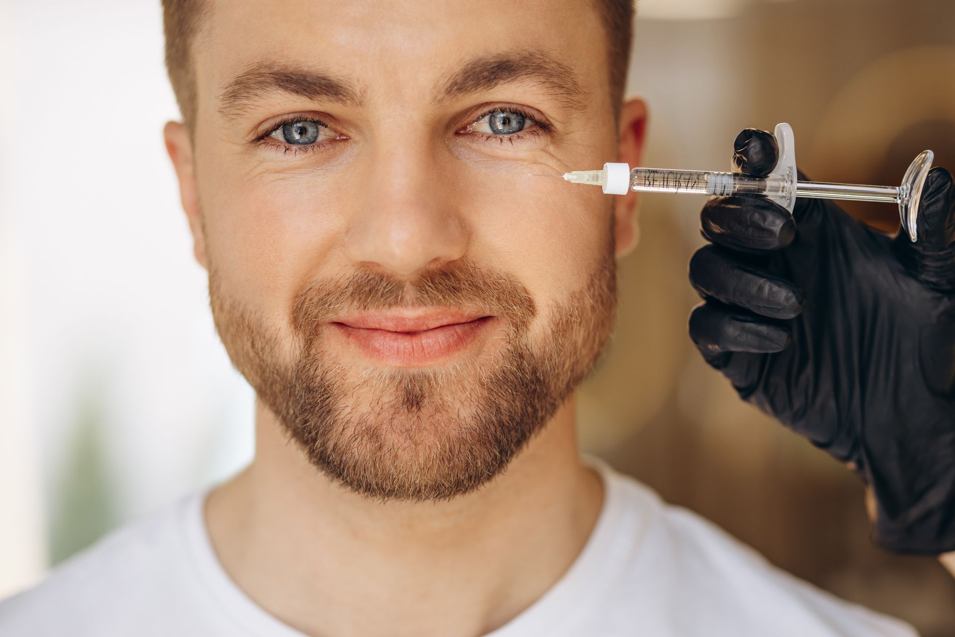 A man is getting a botox injection in his eye.